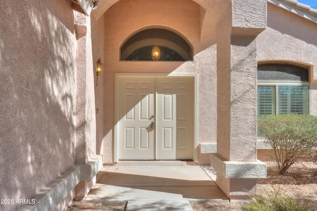 doorway to property featuring stucco siding