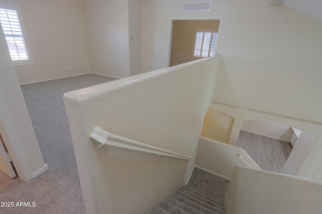 stairway with carpet, a healthy amount of sunlight, visible vents, and baseboards