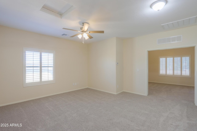 spare room with light carpet, attic access, and visible vents