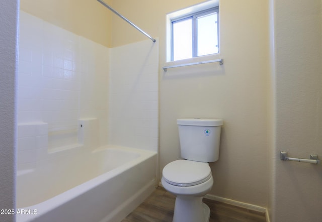 full bathroom featuring  shower combination, wood finished floors, toilet, and baseboards