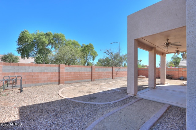 view of yard featuring a ceiling fan, a fenced backyard, and a patio