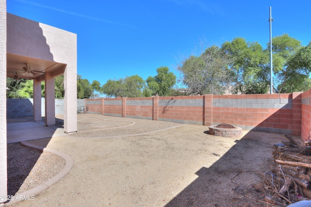 exterior space with a fire pit, ceiling fan, and a fenced backyard