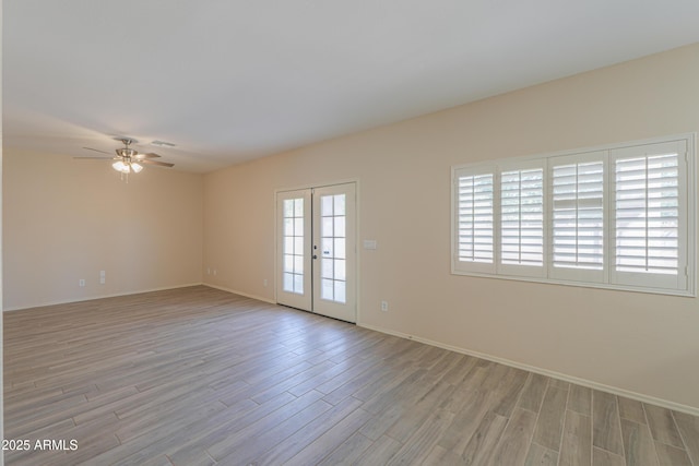 empty room featuring visible vents, baseboards, ceiling fan, french doors, and light wood-type flooring