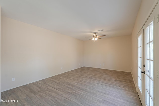 unfurnished room featuring baseboards, visible vents, a ceiling fan, french doors, and light wood-type flooring