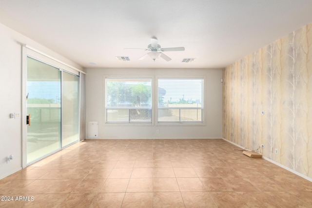 empty room featuring light tile patterned floors and ceiling fan