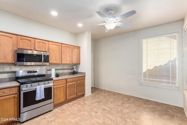 kitchen with backsplash, stainless steel appliances, ceiling fan, and light tile patterned flooring