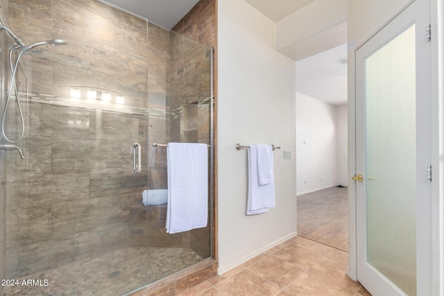 bathroom with a shower with shower door and tile patterned floors