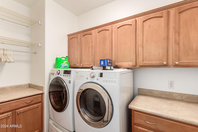 washroom with washer and clothes dryer and cabinets