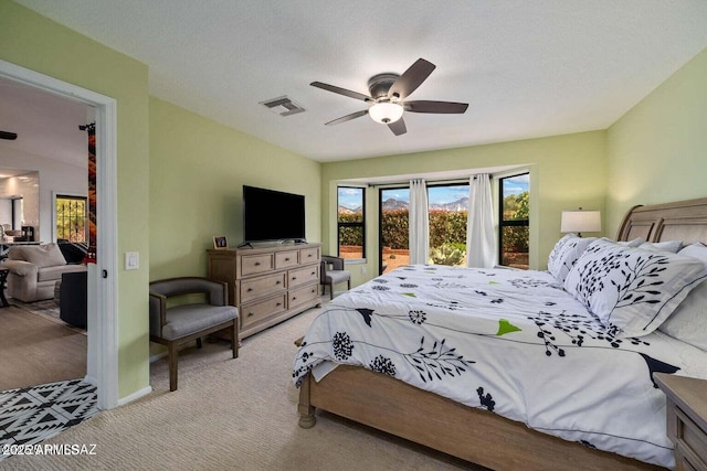 bedroom featuring visible vents, light carpet, and ceiling fan