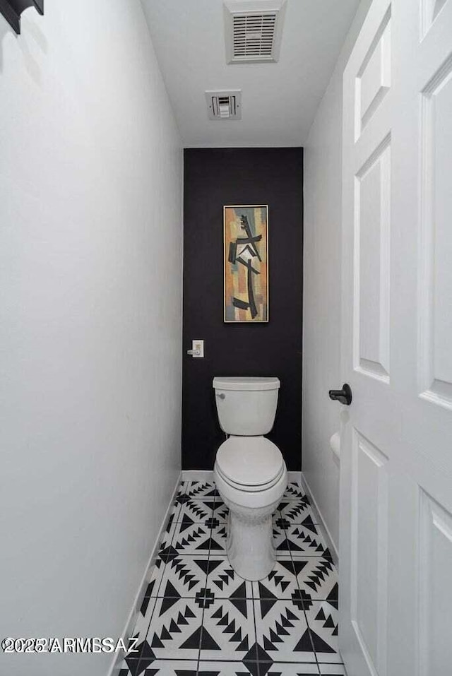 bathroom featuring baseboards, visible vents, toilet, and tile patterned flooring
