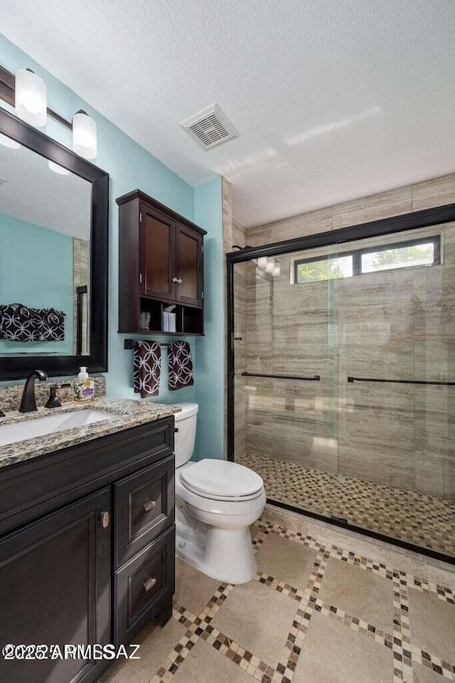 bathroom featuring a shower stall, vanity, tile patterned floors, toilet, and visible vents
