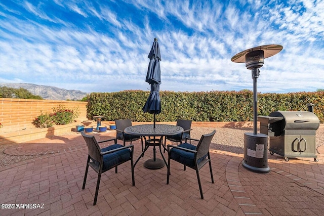 view of patio / terrace featuring a mountain view, outdoor dining space, and a fenced backyard