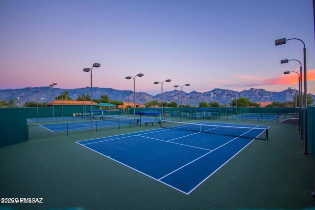 view of tennis court featuring fence and a mountain view