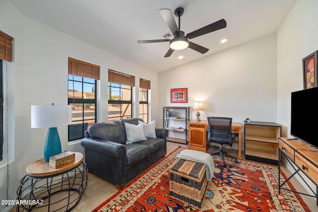 living area featuring light wood finished floors, a ceiling fan, recessed lighting, and lofted ceiling