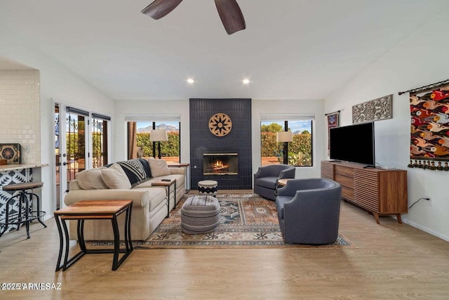 living room with recessed lighting, light wood-style floors, a fireplace, and plenty of natural light