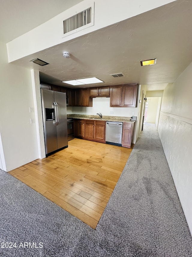 kitchen featuring sink, light wood-type flooring, and stainless steel appliances