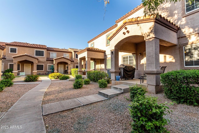 view of front of house featuring a tile roof and stucco siding