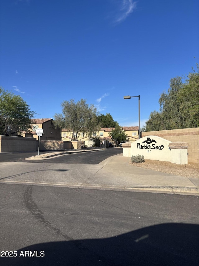 view of asphalt road featuring sidewalks, street lights, and curbs