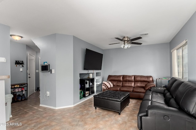 living area with a ceiling fan, light tile patterned floors, and baseboards