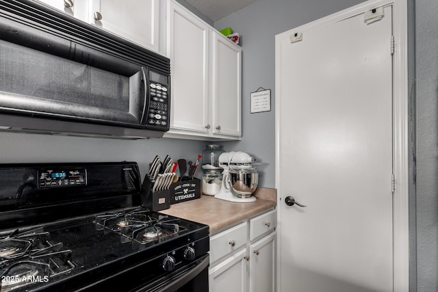 kitchen featuring black appliances, white cabinetry, and light countertops