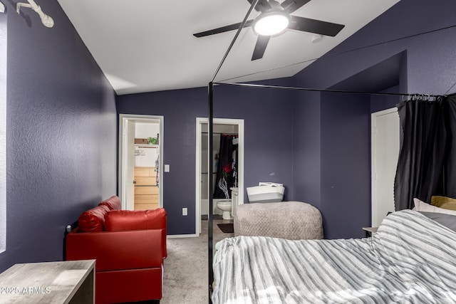 bedroom with vaulted ceiling, carpet, a textured wall, ceiling fan, and ensuite bathroom