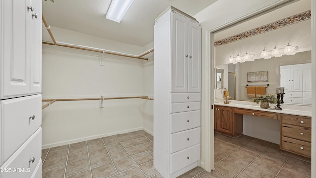 walk in closet featuring light tile patterned floors and built in study area