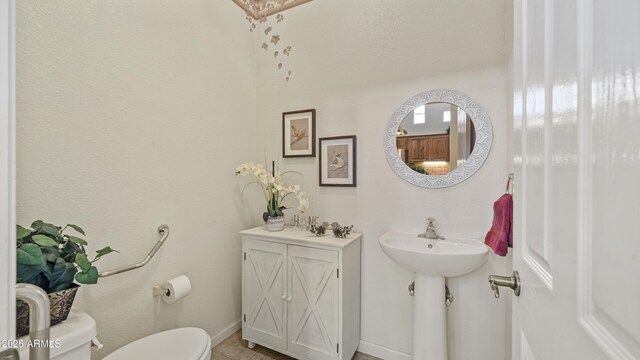 bathroom with tile patterned flooring, toilet, and baseboards