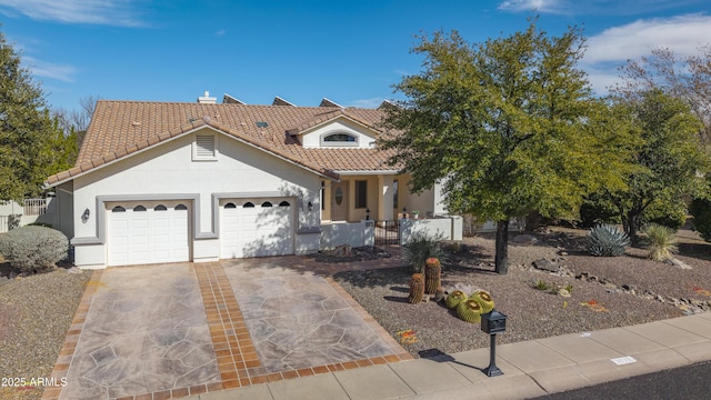 view of front of property with concrete driveway, an attached garage, a tiled roof, and stucco siding