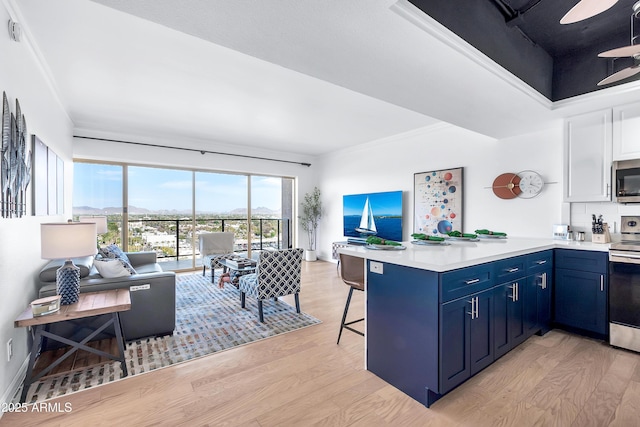 kitchen with blue cabinetry, stainless steel appliances, kitchen peninsula, a kitchen bar, and ornamental molding