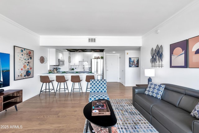 living room with crown molding and hardwood / wood-style floors