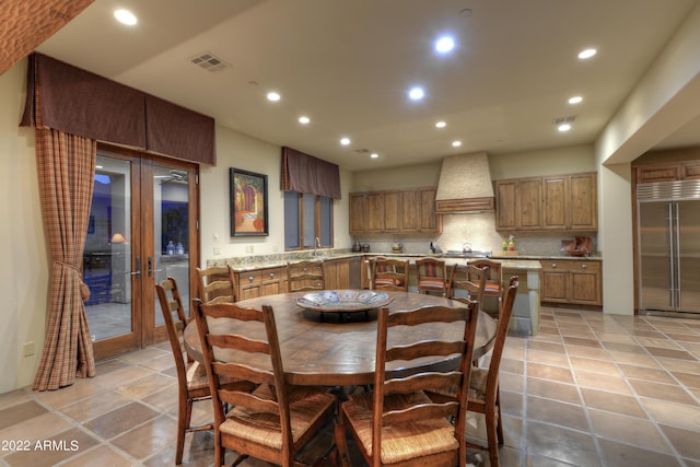 tiled dining space featuring french doors and sink