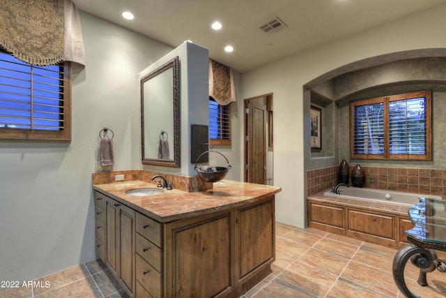 bathroom with vanity and a tub to relax in