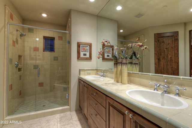 bathroom featuring tile patterned flooring, vanity, a shower with shower door, and decorative backsplash