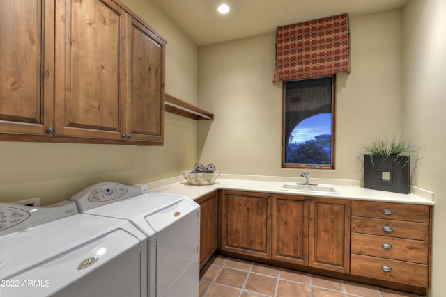 laundry room featuring sink, light tile patterned floors, washer and clothes dryer, and cabinets