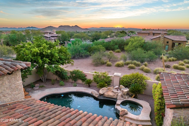 pool at dusk featuring a mountain view