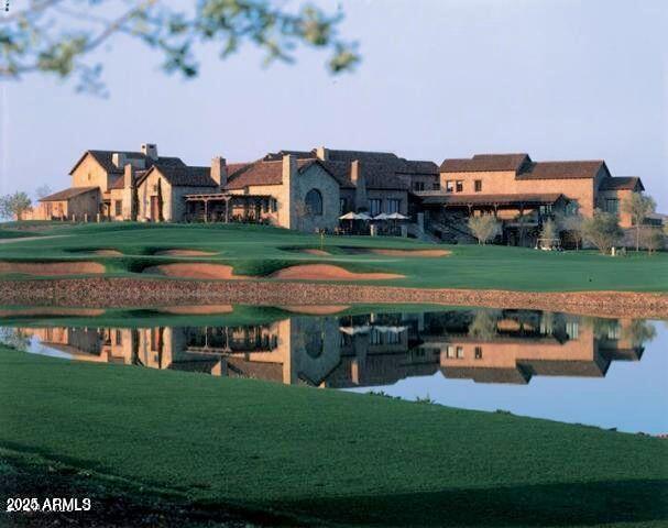 view of property's community featuring a lawn and a water view