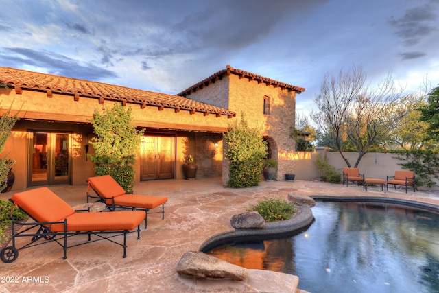 pool at dusk with a patio