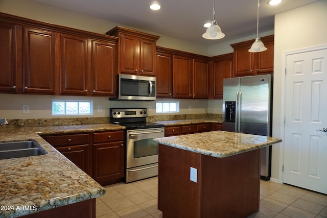 kitchen with a center island, a healthy amount of sunlight, stainless steel appliances, and hanging light fixtures