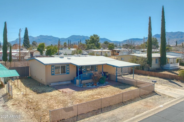 view of front of property featuring a porch, a mountain view, and fence