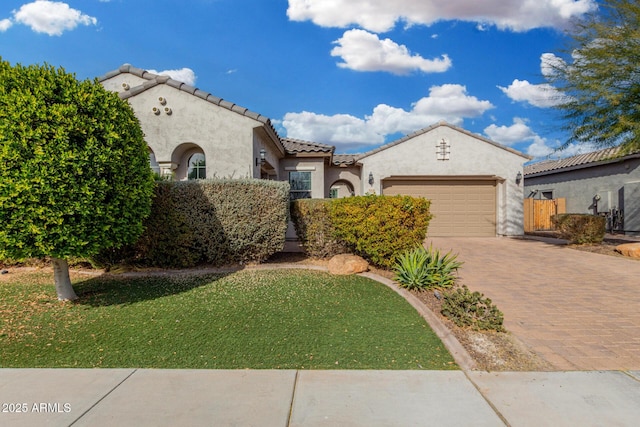 mediterranean / spanish-style home with a garage and a front lawn