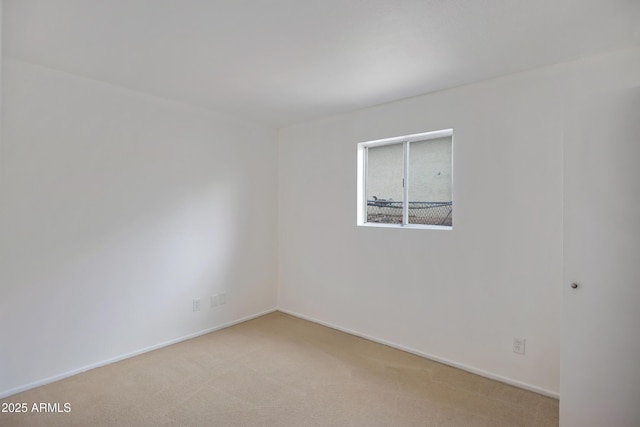 spare room featuring light carpet