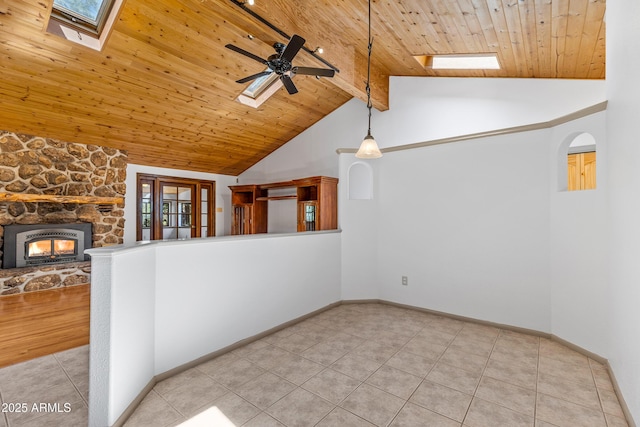 17620 Littlefield Pl, Munds Park, AZ 86017 - unfurnished living room featuring a skylight, a wooden ceiling with exposed beams, light tile patterned floors, a fireplace, and a ceiling fan