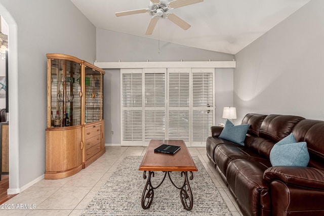 living area featuring lofted ceiling, light tile patterned floors, baseboards, and ceiling fan