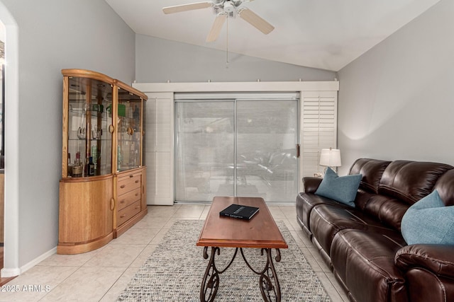 living area featuring vaulted ceiling, light tile patterned floors, baseboards, and ceiling fan