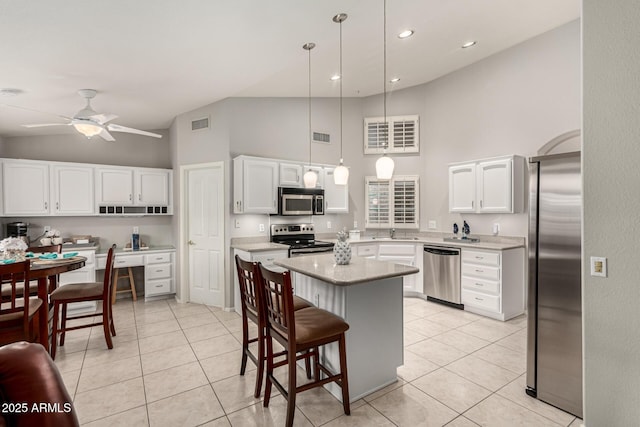 kitchen with a sink, stainless steel appliances, light countertops, and light tile patterned floors