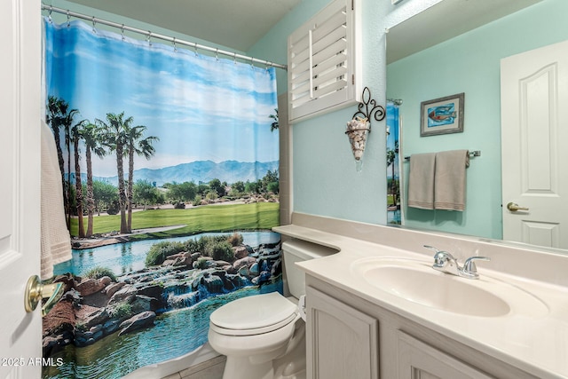 bathroom featuring tile patterned flooring, a mountain view, toilet, and vanity