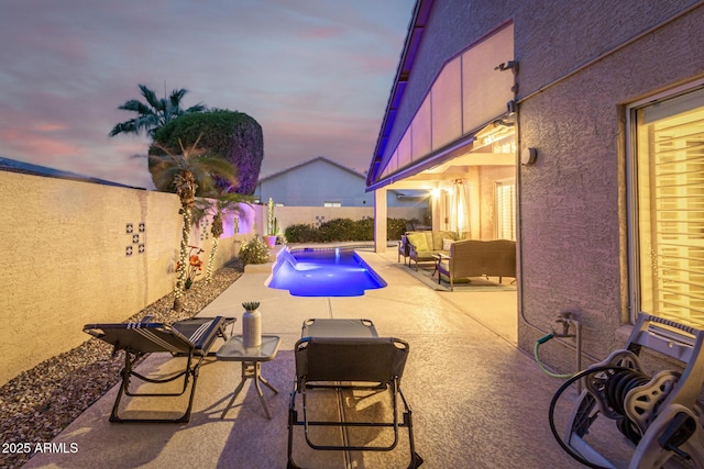 pool at dusk featuring a patio area, a fenced in pool, outdoor lounge area, and a fenced backyard