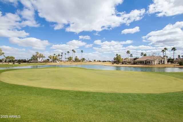 view of property's community with a water view, a lawn, and view of golf course