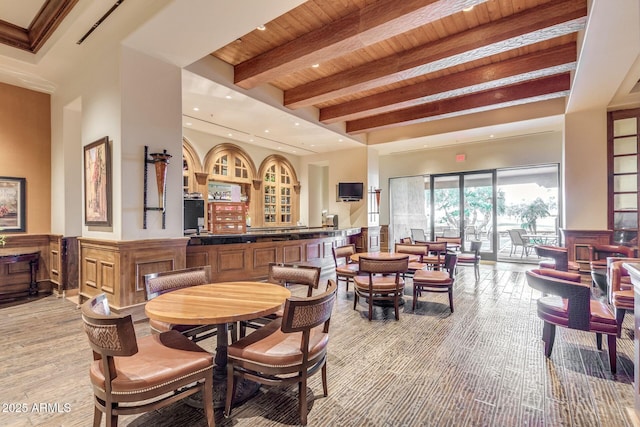 dining space featuring a wainscoted wall, beam ceiling, recessed lighting, wooden ceiling, and light wood-style flooring