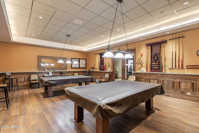 playroom with pool table, a tray ceiling, and wood finished floors